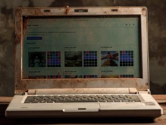 A screenshot of Wordle, Illustrated photoshopped onto an AI-generated image of a dirty old laptop